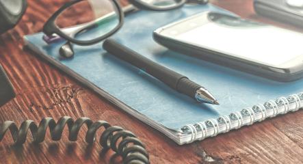 desk with glasses pen and notbook